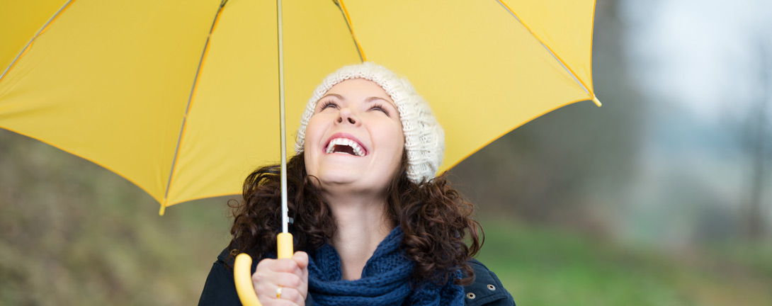 Frau_Schirm_Regen_lachen_gluecklich_natur_deposit_1090x432.jpg